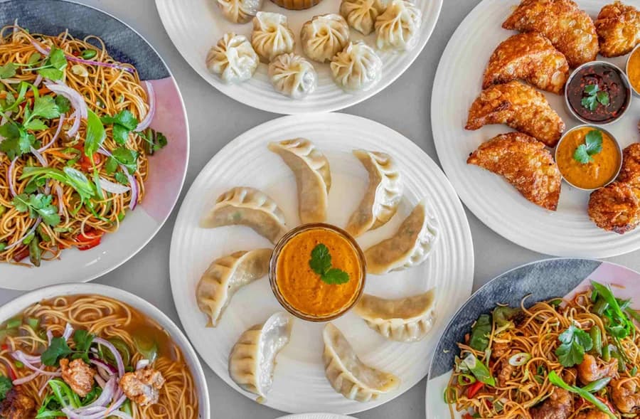 A plate of momos with dipping sauce